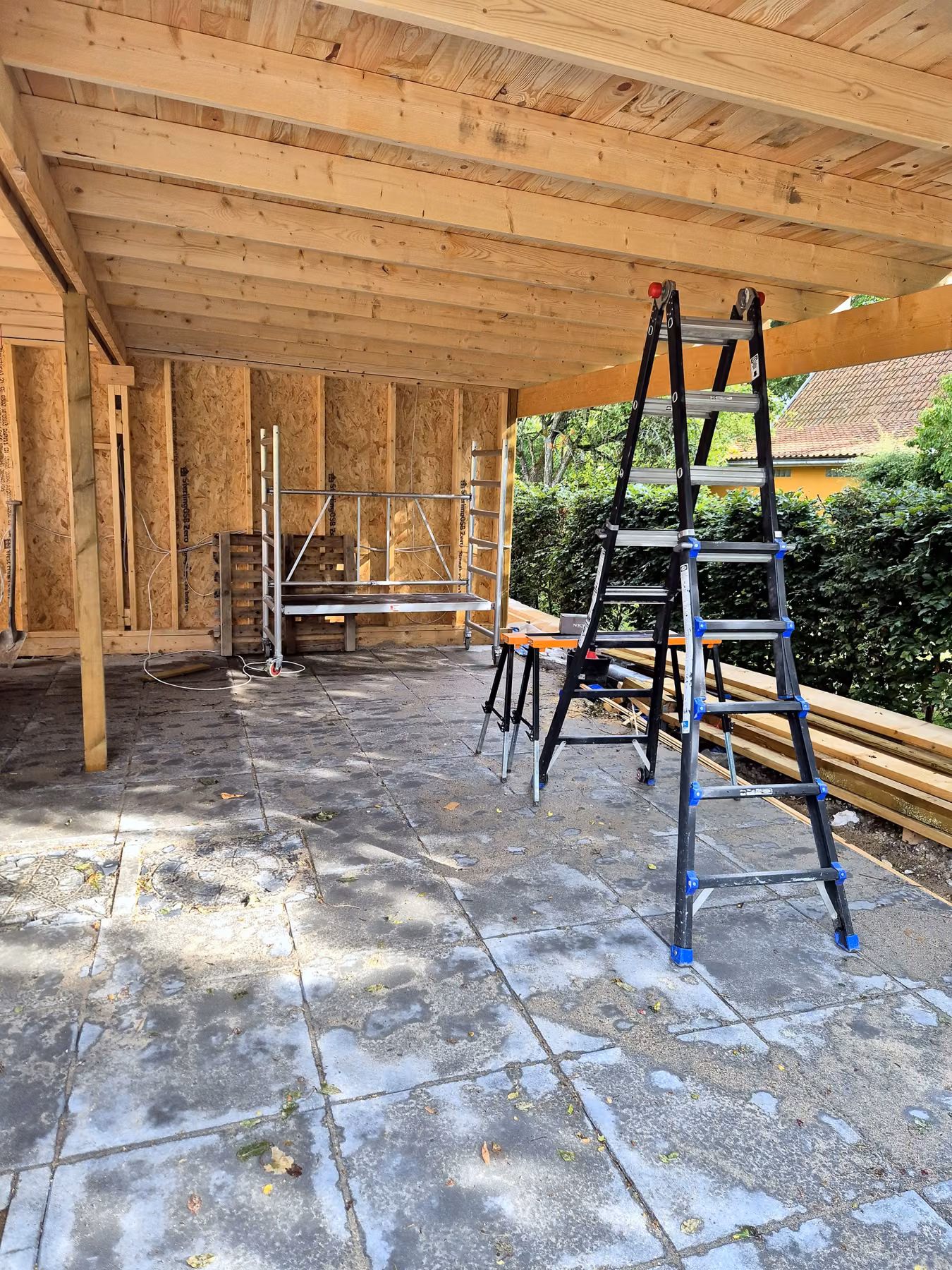 Carporten under opførelse: spær og tag på stolper