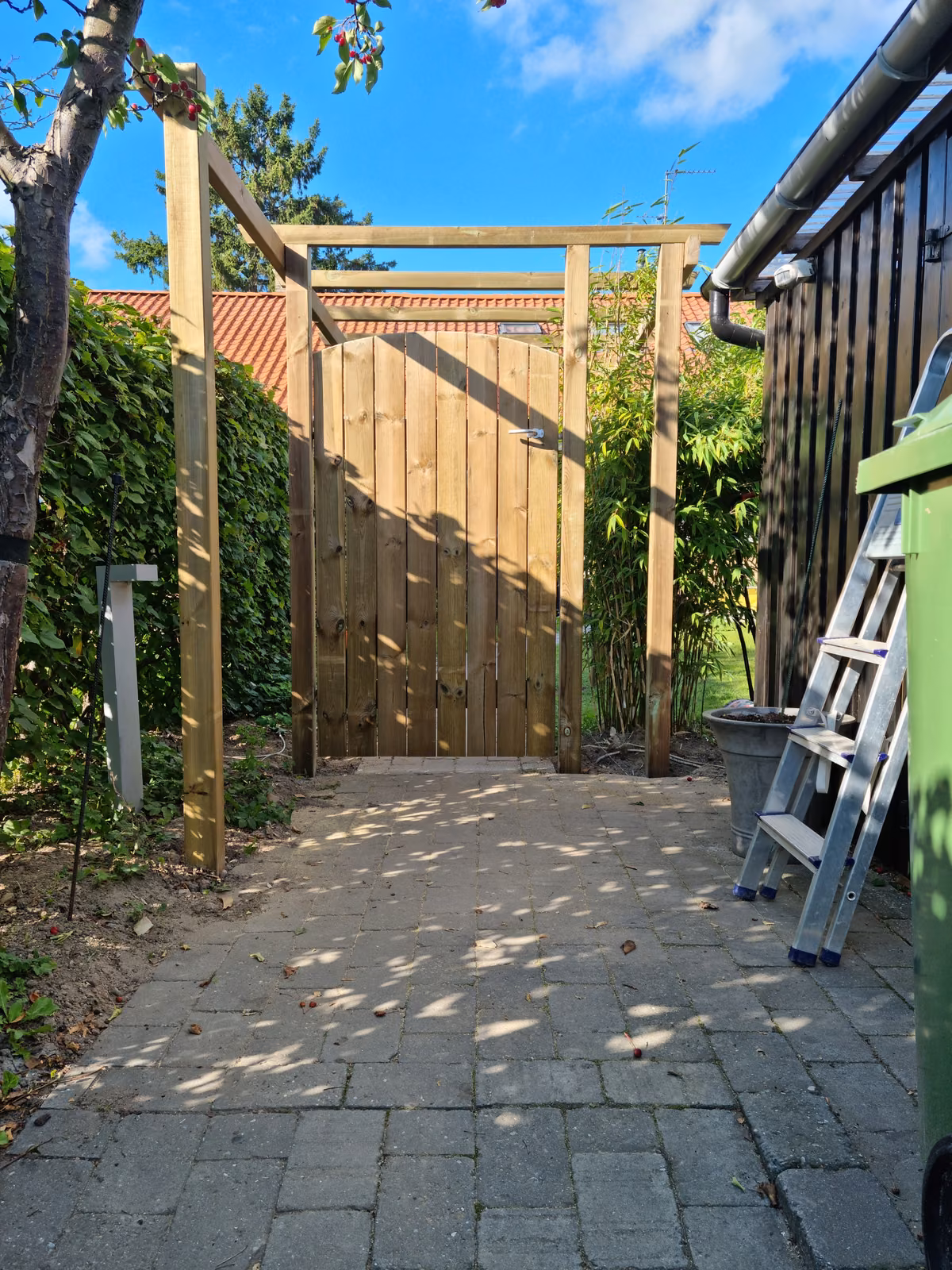 Indgangspartiet med låge og espalier set fra flisegangen, Bagsværd